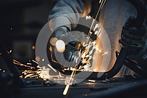 Grinding metal pipe in a workshop and sparks flying