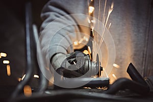 Grinding metal pipe in a workshop and sparks flying