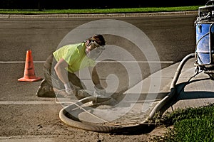 Grinding ragged concrete edge along a road and curb