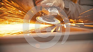 Grinding the seams of an iron frame in the welding workshop - bright sparkles