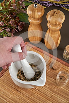 Grinding spices herbs in a mortar with pestle