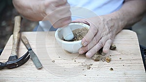 Grinding up oak galls for ink making