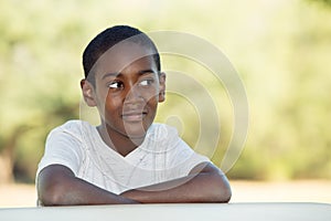 Grinning boy with folded arms at table