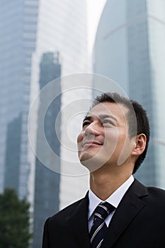 Grinning businessman looking up