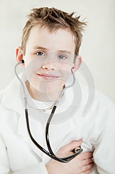 Grinning child checking his pulse with stethoscope