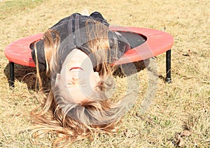 Grinning girl lying on trampoline