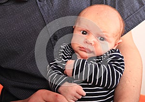 Grinning newborn baby boy with big eyes