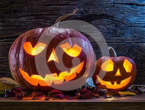 Grinning pumpkin lantern or jack-o`-lantern is one of the symbols of Halloween. Halloween attribute. Wooden background