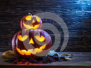 Grinning pumpkin lantern or jack-o-lantern is one of the symbols of Halloween. Halloween attribute. Wooden background