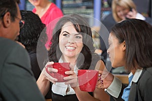 Grinning Woman with Coffee and Coworkers