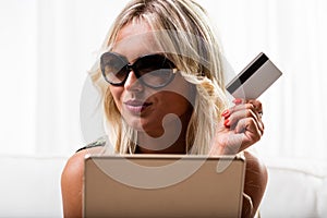 Grinning woman with credit card and tablet