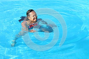 Grinning woman swimming in pool