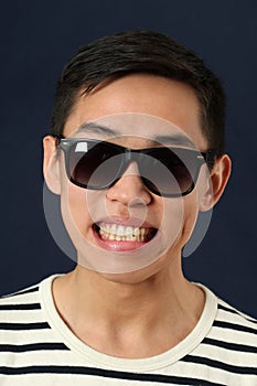 Grinning young Asian man in sunglasses