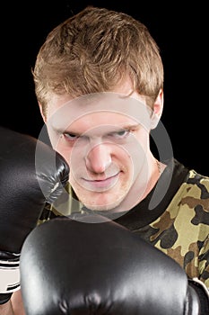 Grinning young man in boxing gloves