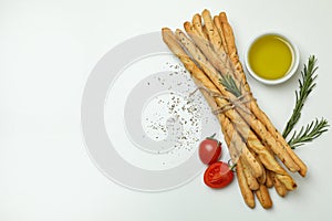Grissini breadsticks with spices on white background