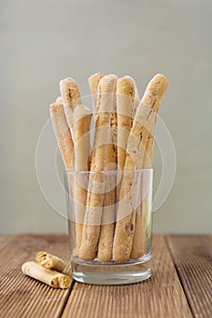 Grissini on wooden table. Traditional italian snack with herbs. Copy space. Vertical image