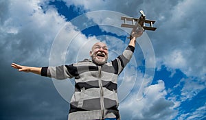 grizzle senior man on sky background. senior man at retirement. senior retired man with toy plane