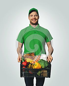 Groceries delivery - man in green uniform with food box photo