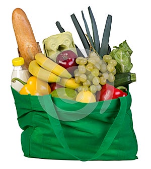 Groceries in green bag isolated on white photo