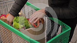 Groceries from a supermarket in a trolley outdoors. Food delivery during quarantine. Cruft Paper eco bags for shopping