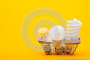 In the grocery basket are different types of light bulbs - incandescent, energy-saving and LED