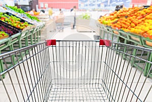 Grocery cart in fruit department of supermarket