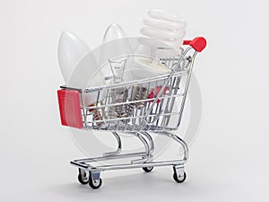 In the grocery cart are three light bulbs: incandescent, energy-saving and LED