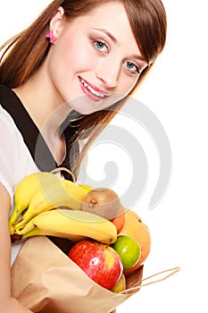 Grocery. Girl holding paper shopping bag with fruits