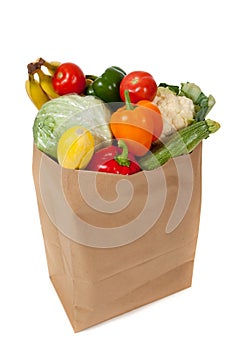 Grocery sack full of vegetables on white