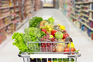 Grocery shopping cart with vegetables. photo