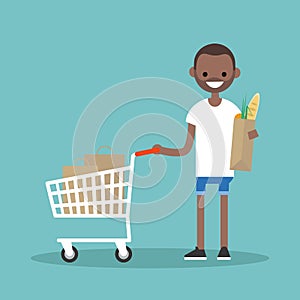 Grocery shopping concept: Young customer standing with a trolley