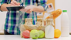 Grocery shopping list woman checking milk fruit