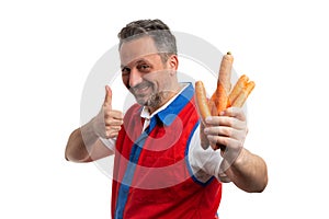 Grocery store employee making like gesture preseting carrots