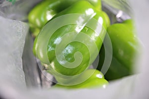 Grocery store fresh organic green peppers inside a plastic bag