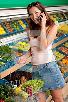 Grocery store - Smiling woman with mobile phone