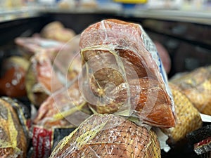 Grocery store whole hams on display close up