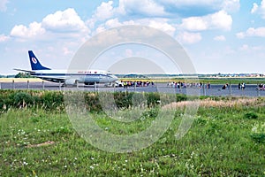 GRODNO, BELARUS - AUGUST 2019: crowd of tourists near the plane awaiting flight. Aircraft that await passengers