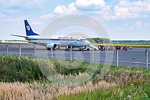 GRODNO, BELARUS - AUGUST 2019: crowd of tourists near the plane awaiting flight. Aircraft that await passengers