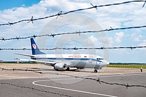 GRODNO, BELARUS - AUGUST 2019: plane awaiting flight behind the barbed wire. Aircraft that await passengers