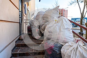 Grodno, Belarus, February 25, 2022: New arrival of clothes in a second-hand store. Old used clothes in large plastic bags.