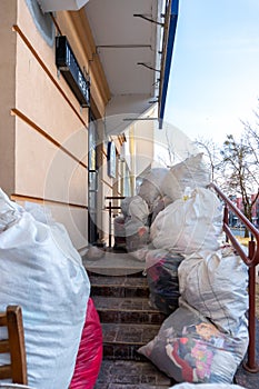 Grodno, Belarus, February 25, 2022: New arrival of clothes in a second-hand store. Old used clothes in large plastic bags.