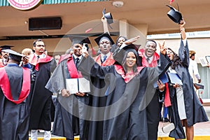 GRODNO, BELARUS - JUNE, 2018: Happy foreign african medical students in square academic graduation caps and black raincoats during