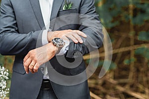 Groom awaiting his bride watching the time pass on clock