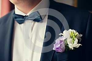Groom in black suit with flower buttonhole