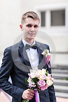 Groom with a bouquet of wedding flowers