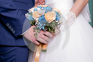 Groom with the bride, the bride`s bouquet, the bride is holding a bouquet, the bridegroom embraces the bride