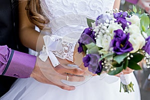 Groom with the bride, the bride`s bouquet, the bride is holding a bouquet, the bridegroom embraces the bride