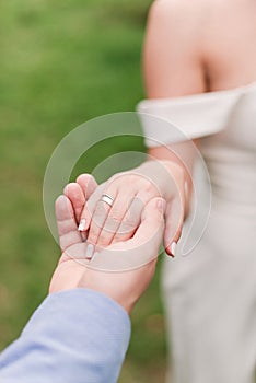 the groom and the bride hold hands. White wedding dress