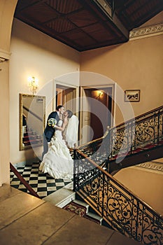 Groom and bride hugging and kissing on the background corridor