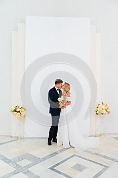 the groom and the bride kiss at the official wedding ceremony